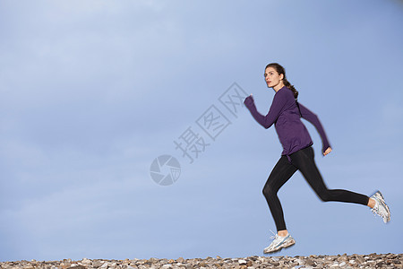 沿着鹅卵石滩慢跑的女人图片
