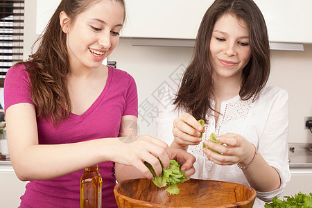 十几岁的女孩在厨房准备沙拉图片