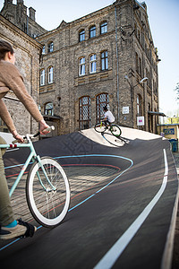 在拉脱维亚里加的城市赛车场，男子和女子骑自行车上坡背景图片