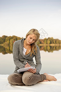 年轻女子在湖边写生图片
