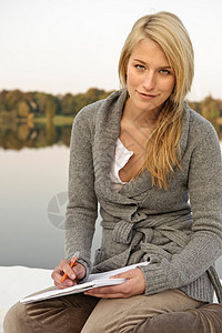年轻女子在湖边写生图片