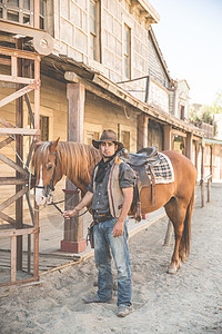西班牙阿尔梅里亚塔伯纳斯布拉沃堡野生西部电影集上的牛仔和马的肖像图片