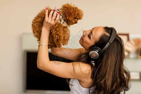 睡前音乐戴着耳机和与狗共舞的中年妇女背景