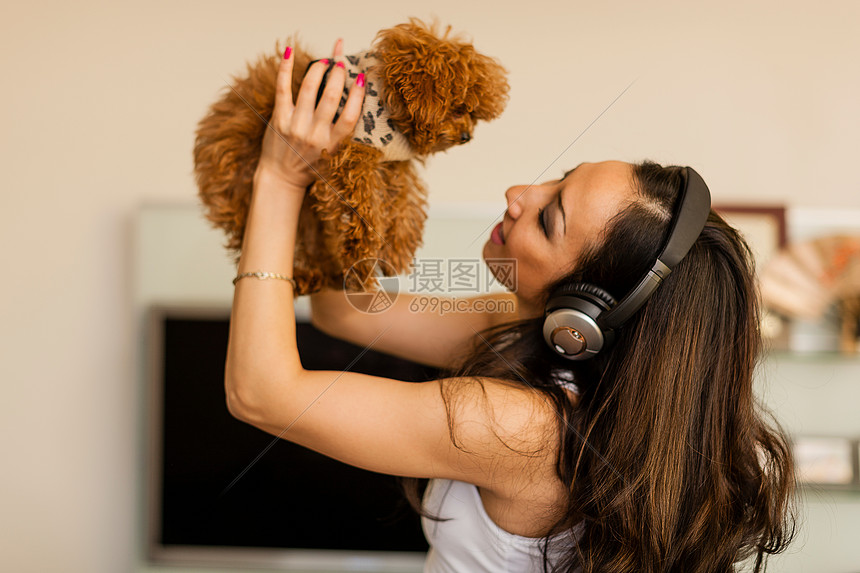 戴着耳机和与狗共舞的中年妇女图片