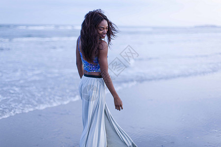 年轻黑人女子沙滩上回眸背景图片