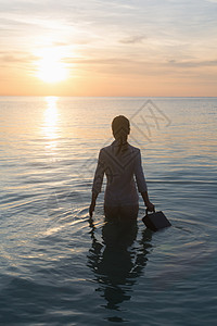 商务女士站在海水中背景图片