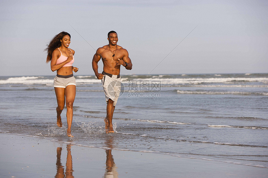 夫妻俩在海滩上奔跑图片