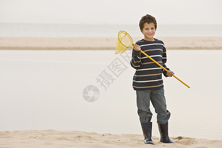 海滩上的小男孩拿着渔网图片