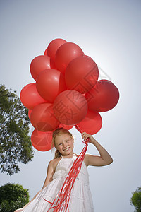 拿着一束红气球的小女孩图片
