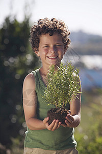 抱着植物的男孩图片