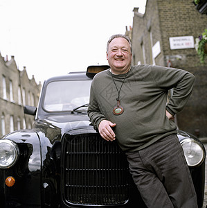 英国伦敦出租车司机靠在黑色出租车上的照片图片