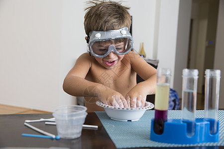 戴着护目镜的男孩在碗里玩混合物图片