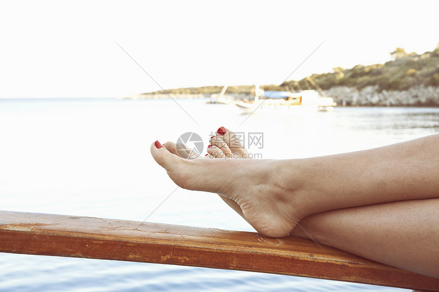 年轻女性游客腿部和海洋图片