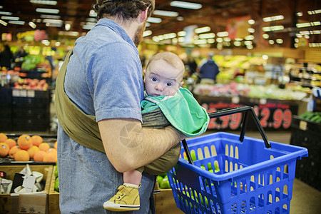 婴儿超市爸爸抱着儿子和购物篮在超市里背景