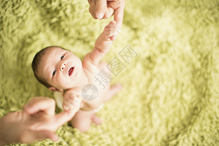 父亲握着女婴的手，高角度图片