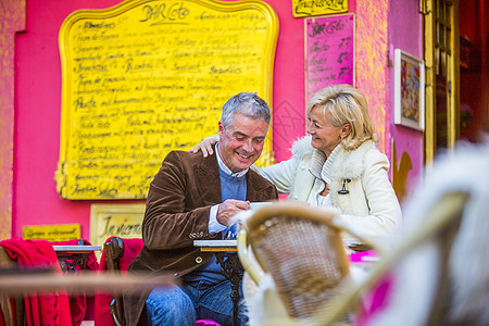 在西班牙马略卡彩色人行道咖啡馆喝咖啡的成年夫妇背景图片