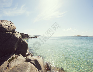 英国苏格兰赫布里底群岛巴拉岛阳光照耀下的大海和海岸岩石群图片