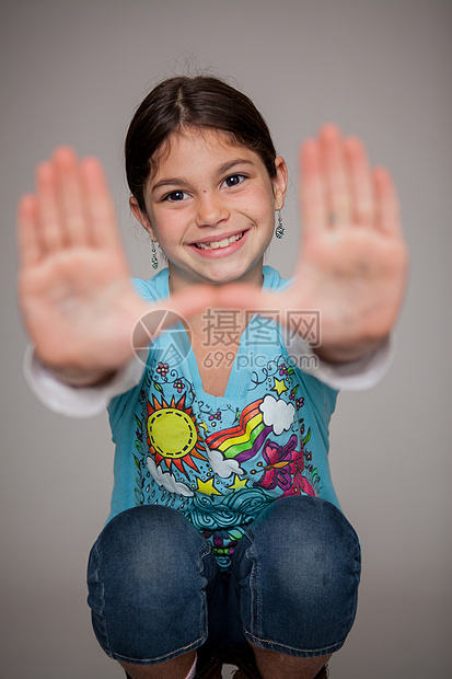 画室里举着手蹲着的女孩图片