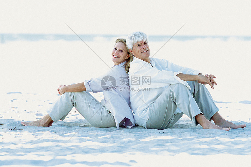 一对夫妇坐在海滩边图片