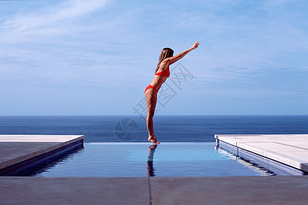 海边游泳池的年轻女子背景图片