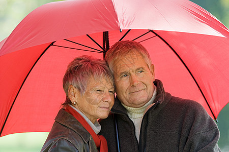 戴红色雨伞的老年夫妇图片