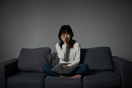 坐在路边崩溃伤心的商年轻女性坐在沙发上哭泣背景