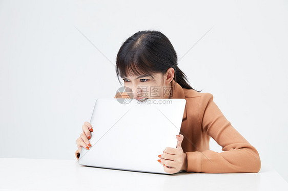 青年女性厌烦工作啃电脑图片