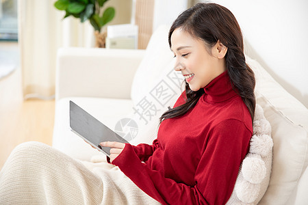 冬季女性居家看平板电脑背景图片