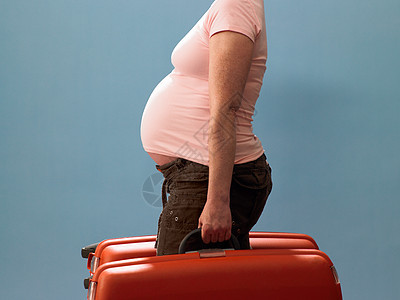 携带手提箱的孕妇图片