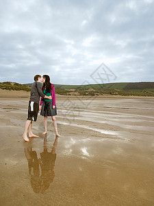 年轻夫妇在海滩上接吻图片