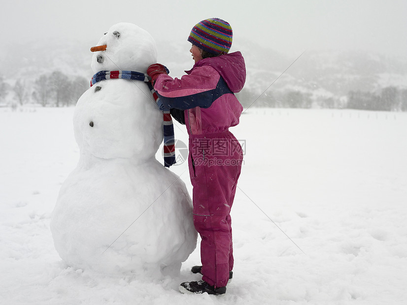 女孩给雪人系围巾图片