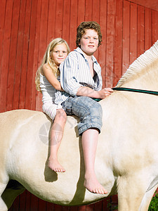 小男孩和小女孩在骑马图片