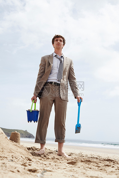 海滩玩沙子的商务男士图片