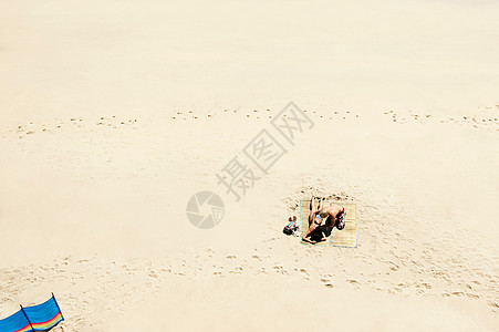在白色沙滩上晒日光浴的夫妇图片
