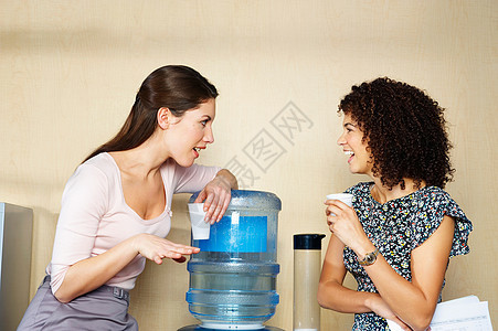 两个女人在饮水机旁聊天图片