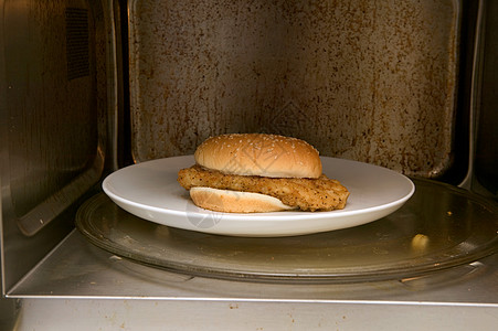 微波炉里加热鸡肉汉堡背景图片