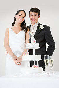 站在结婚蛋糕旁的新婚夫妇图片