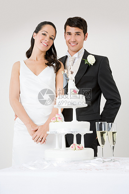 站在结婚蛋糕旁的新婚夫妇图片