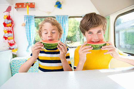 在大篷车里吃西瓜的男孩们背景