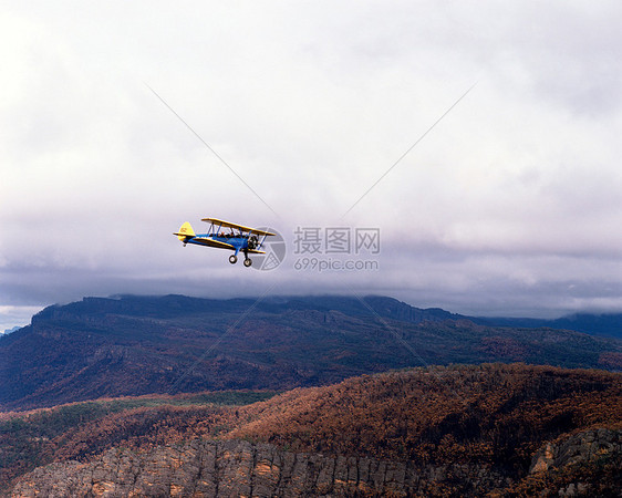 背景中有山脉的双翼飞机图片