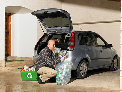 将回收物装入汽车的人图片
