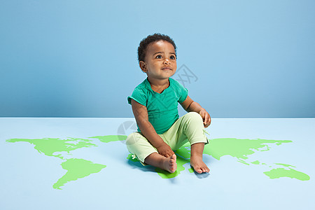 坐在世界地图上的小男孩图片