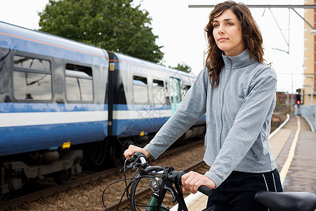 在火车站骑自行车的女人图片