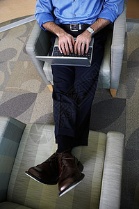 坐在椅子上带笔记本电脑的办公室工作人员图片