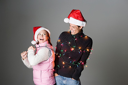 一对夫妇圣诞节用彩灯庆祝背景图片