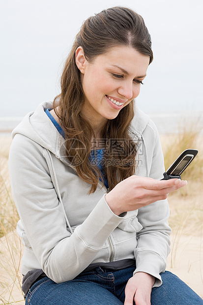 女子在海滩上用手机图片