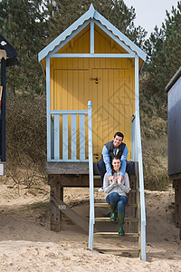 一对夫妇坐在海滩小屋的台阶上图片
