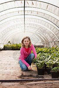 在波利隧道里跪在植物旁的女孩图片