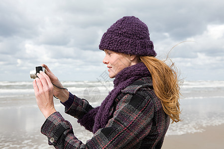海边的女人使用照相机图片