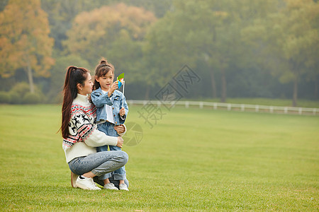 可爱母女草坪上玩风车图片